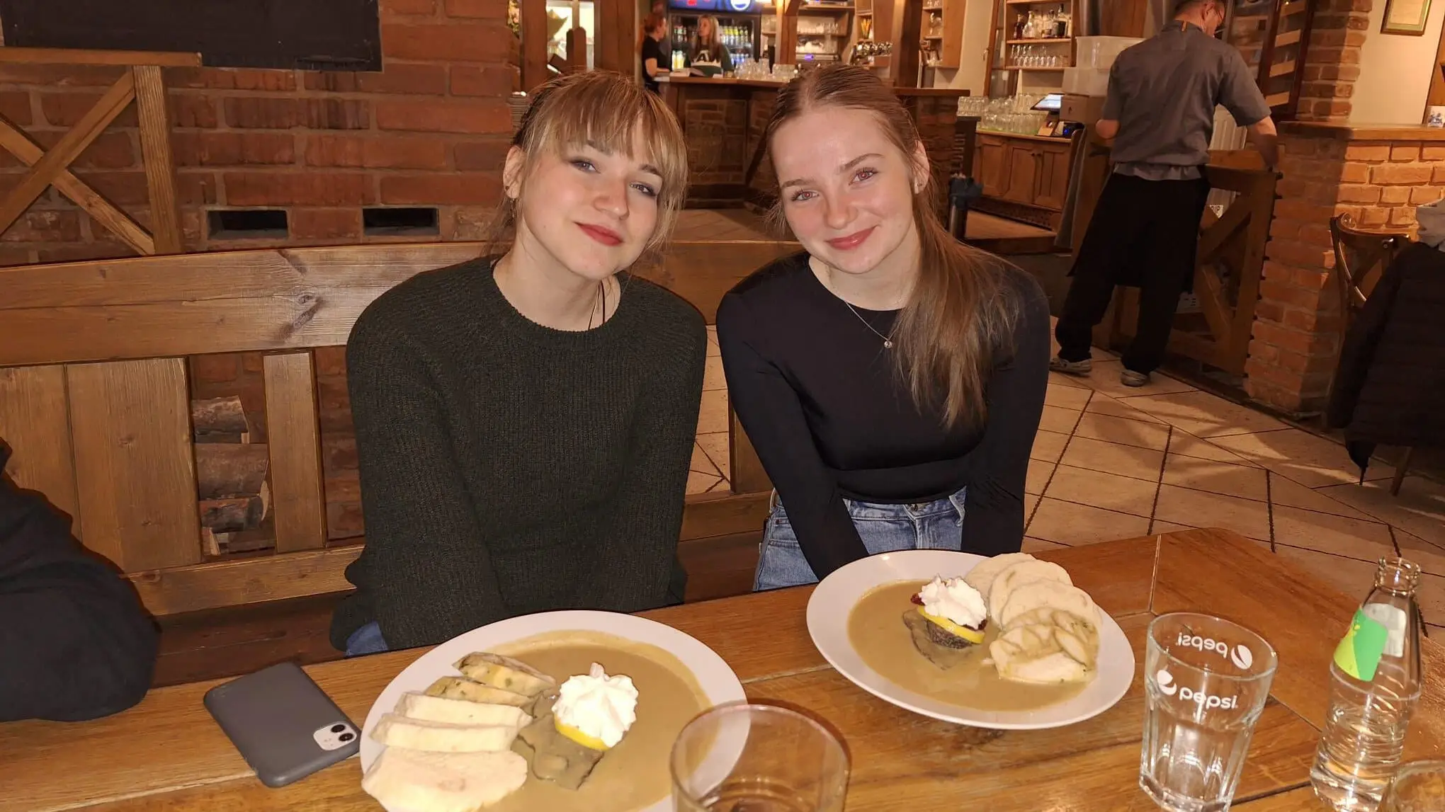 Laura sitzt mit ihrer Austauschpartnerin Eli in einem Restaurant in Pilsen und isst ein typisch tschechisches Gericht