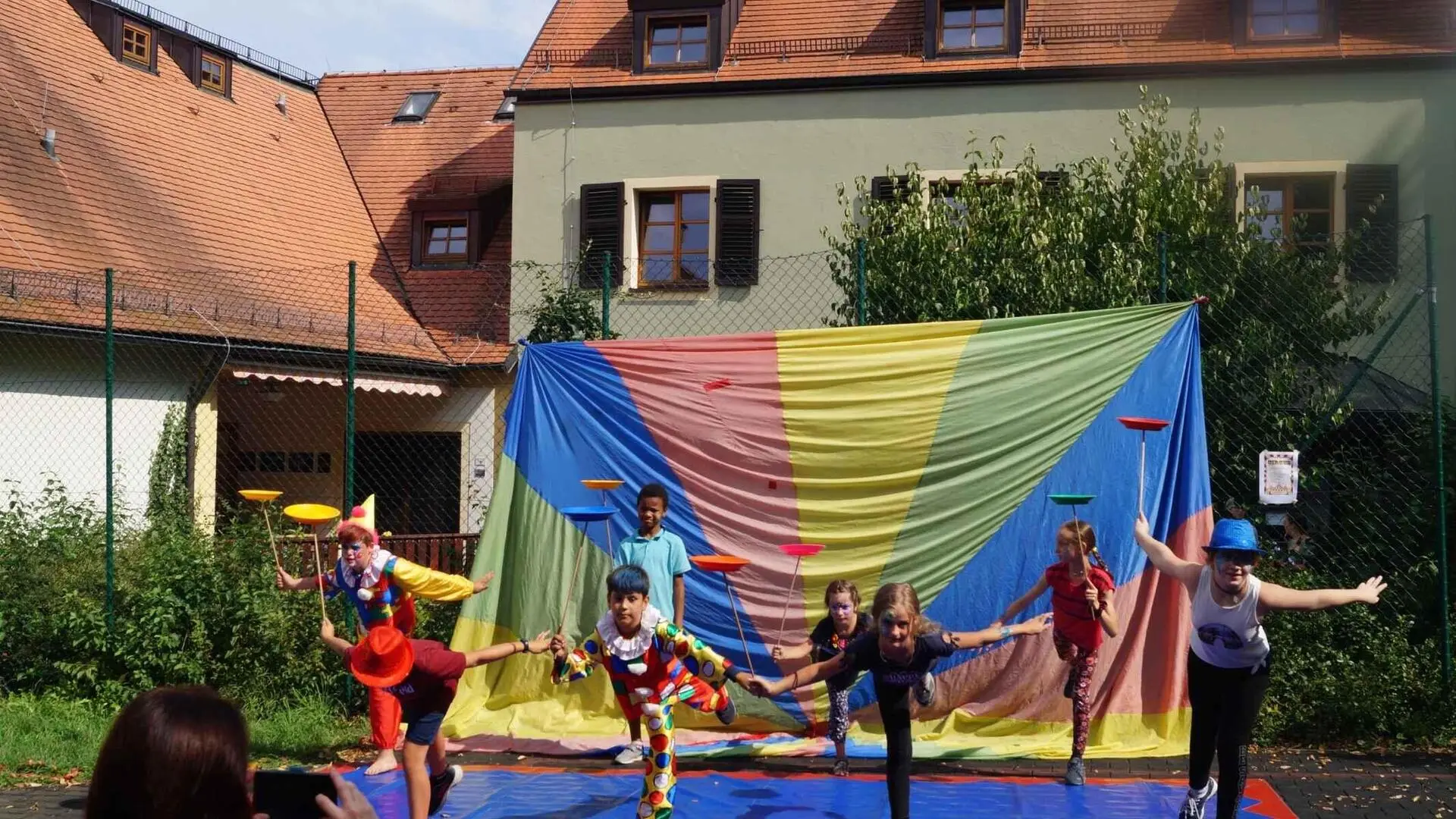 Regenbogenlaken und davor schauspielende Kinder