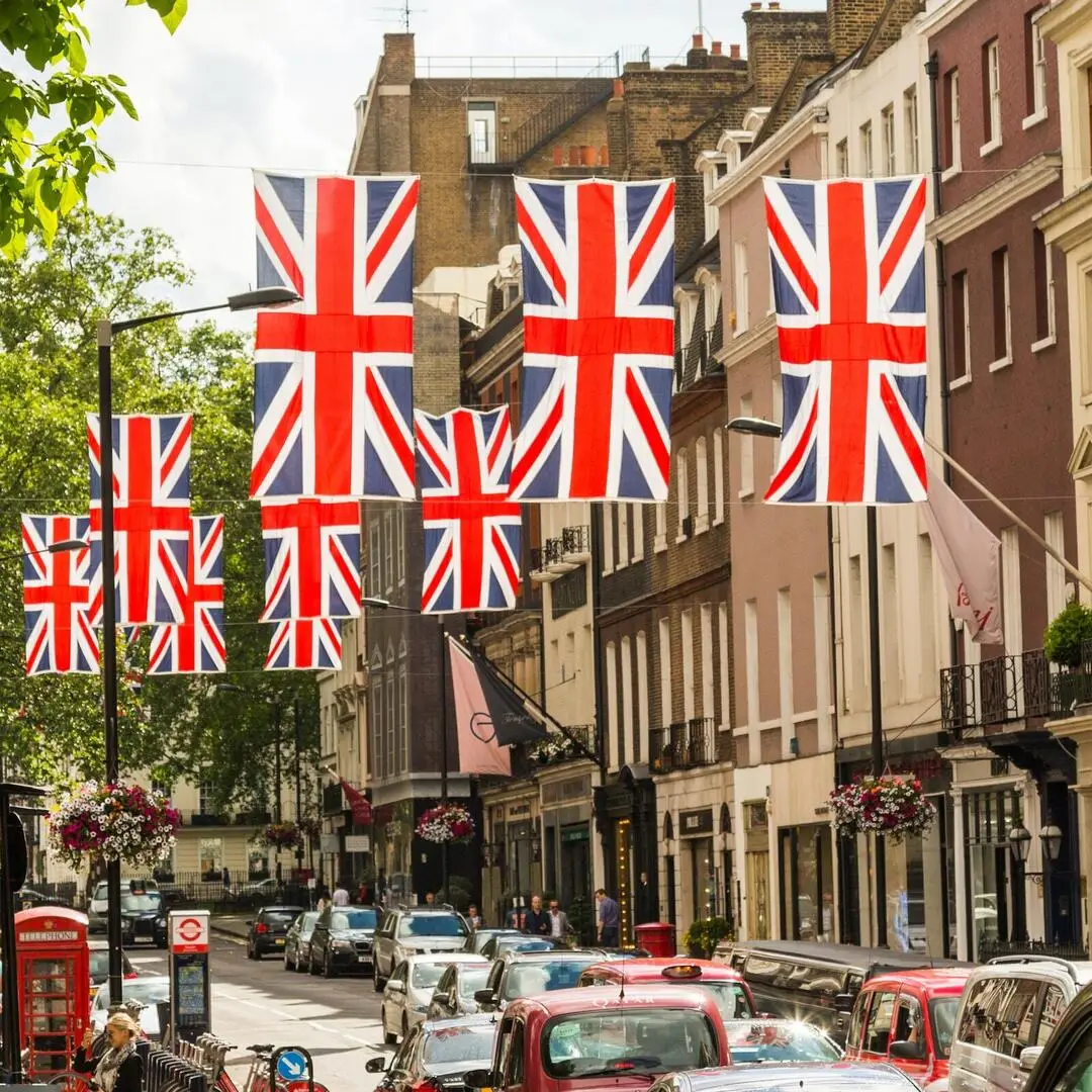Britische Flaggen an Häusern Mehrere Reihen britischer Flaggen hängen über einer Straße.