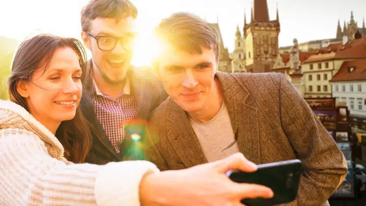 Drei Jugendliche bei Selfie im Hintergrund eine Burg