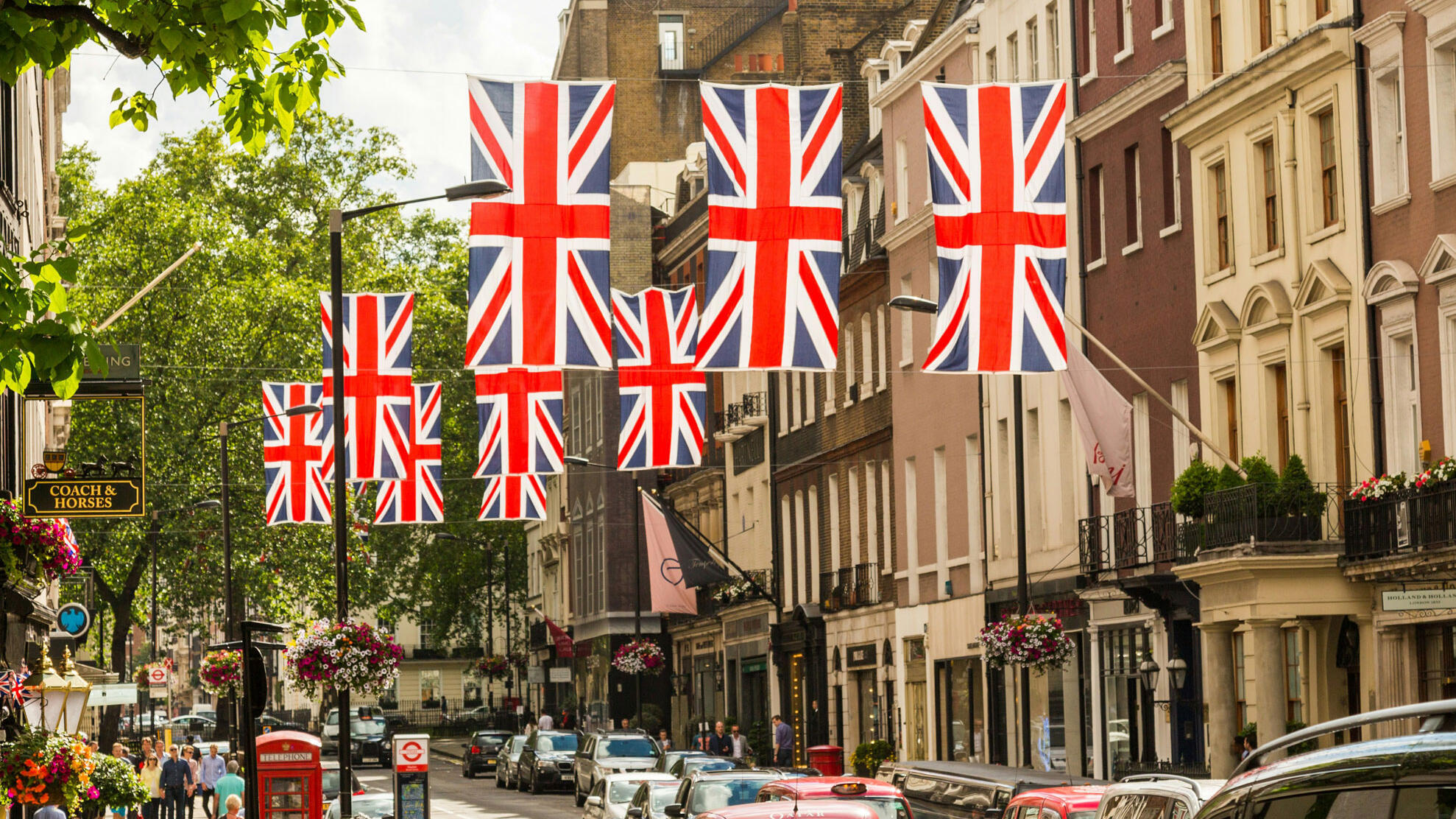 Straße mit Menschen und Union Jack-Flaggen