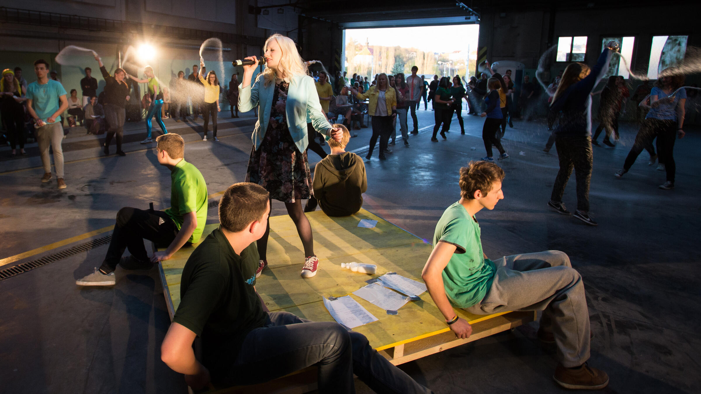 Theaterbühne mit jungen Menschen in Werkhalle