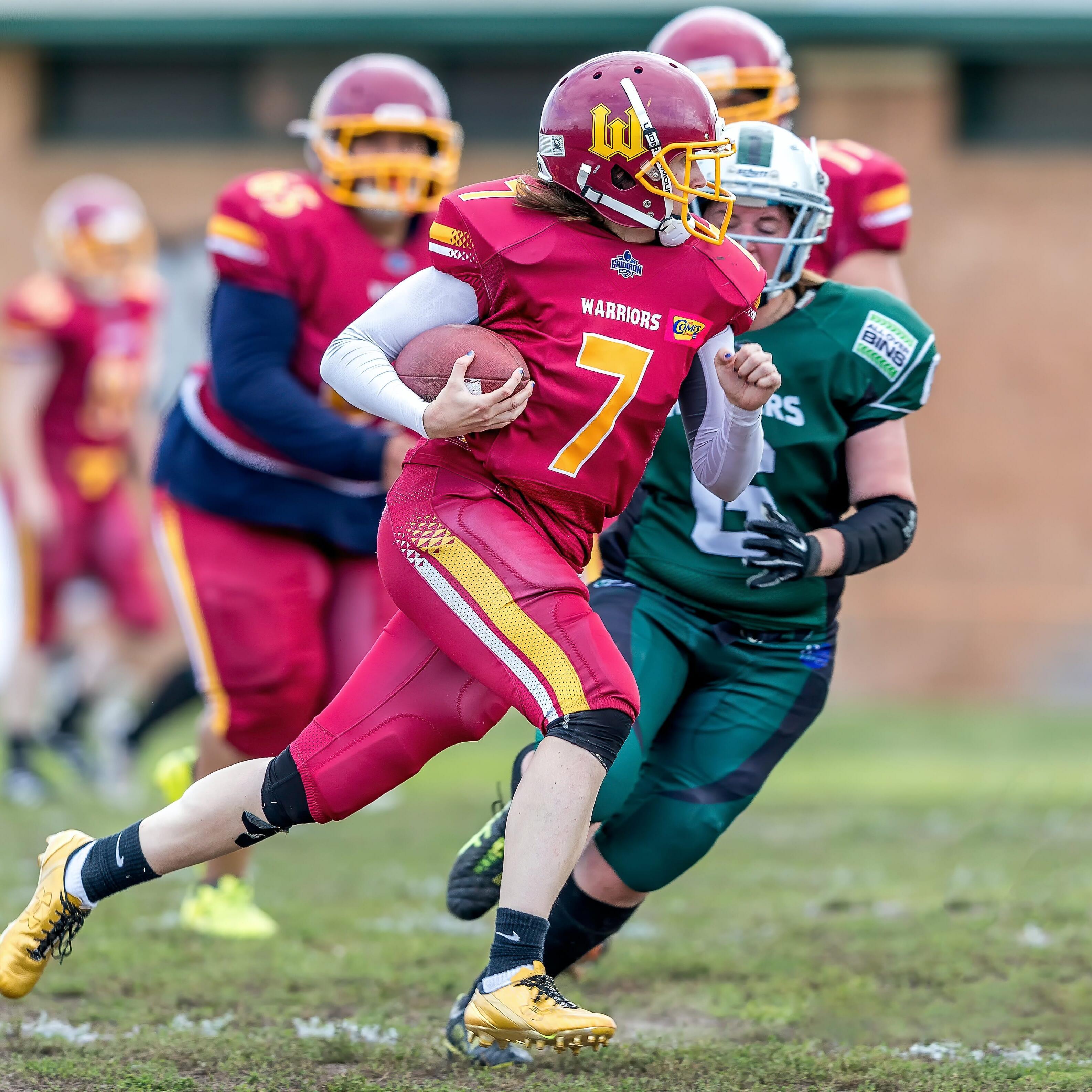 Footballspieler Footballspieler, die auf einem Spielfeld laufen