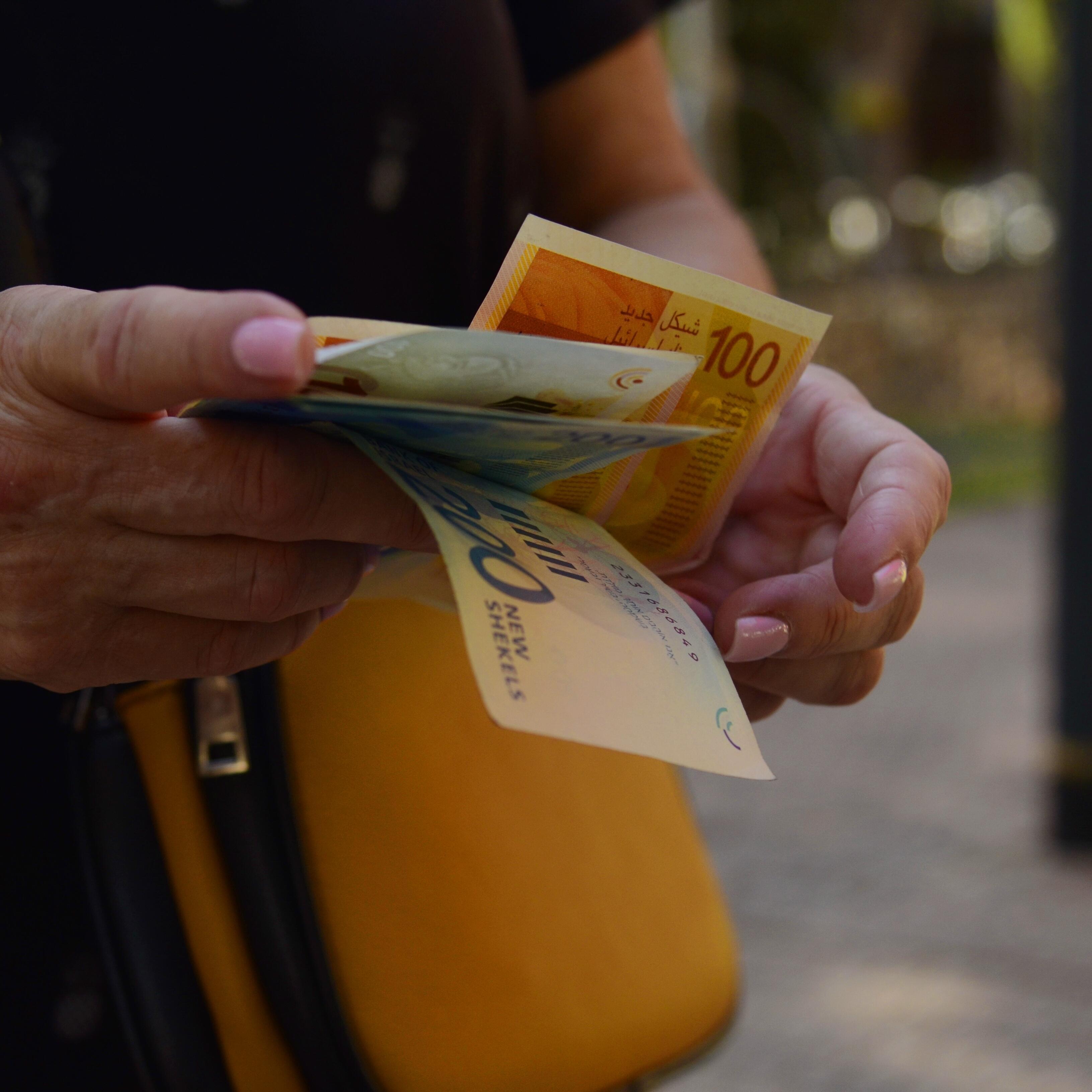 Israelische Schekel Frau hält israelische Schekel in der Hand