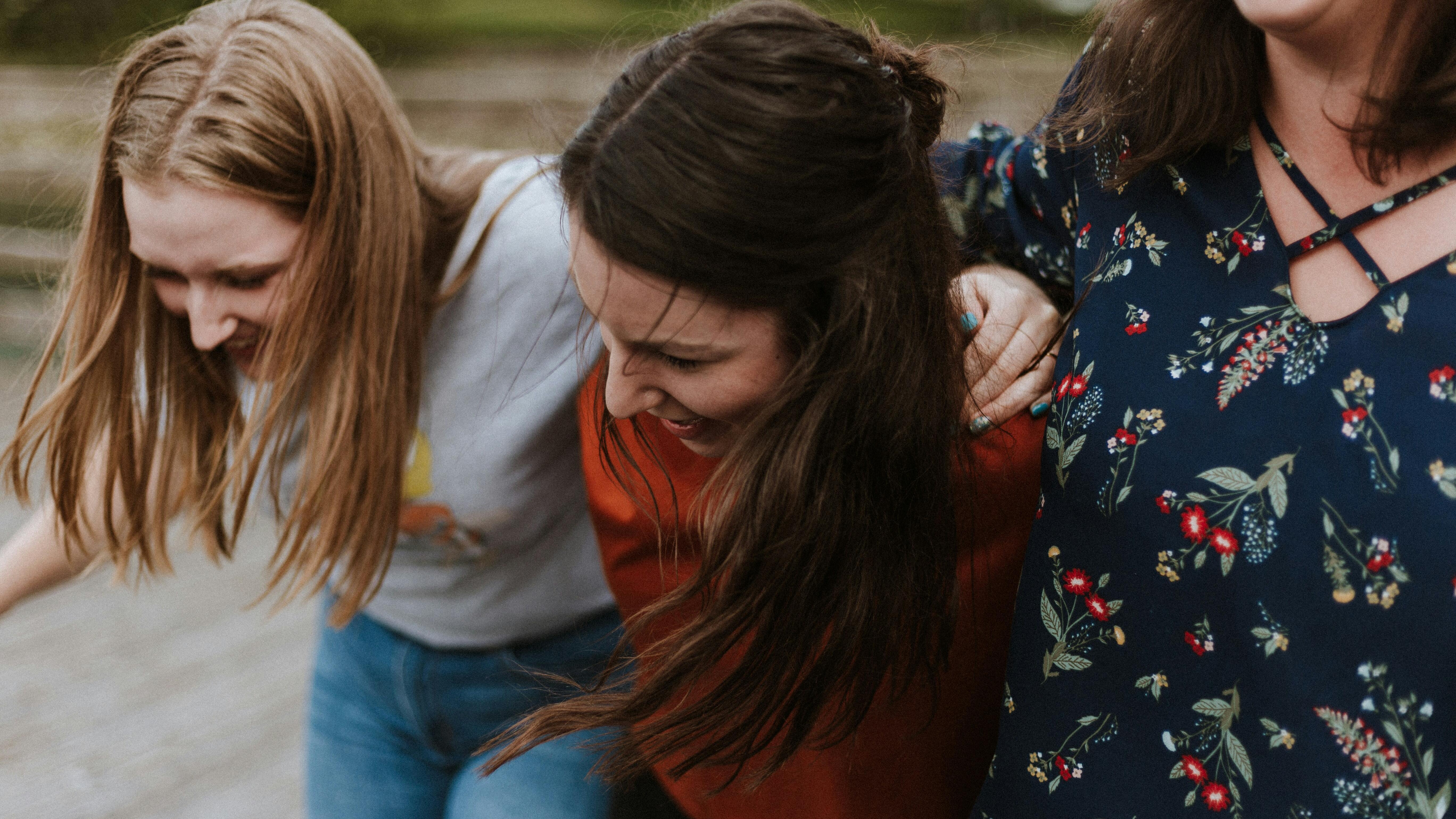 unsplash.com | Prisilla du Preez Drei junge Frauen laufen lachend und untergehakt eine Straße