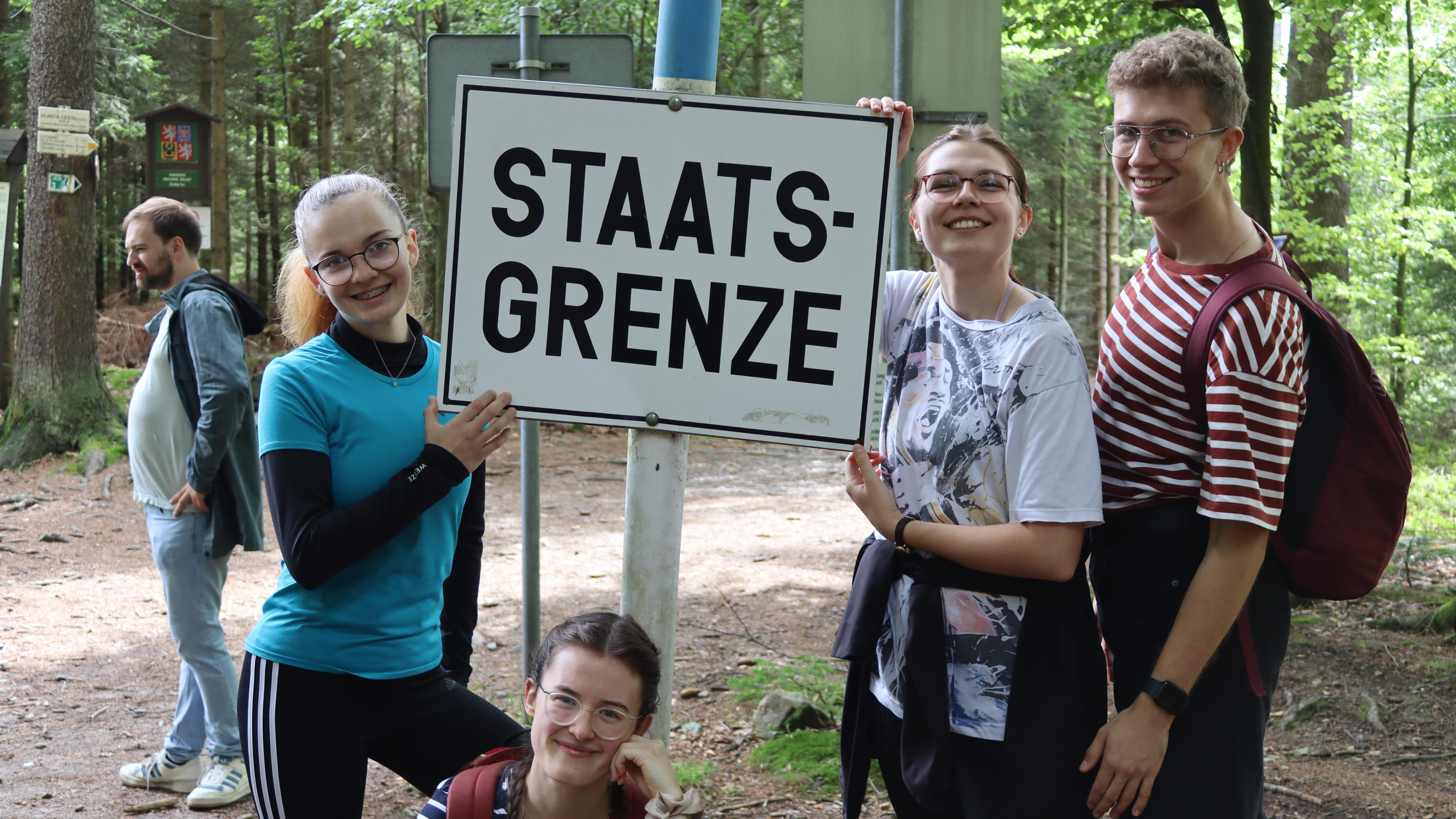 Fünf Jugendliche mit Schild Staatsgrenze