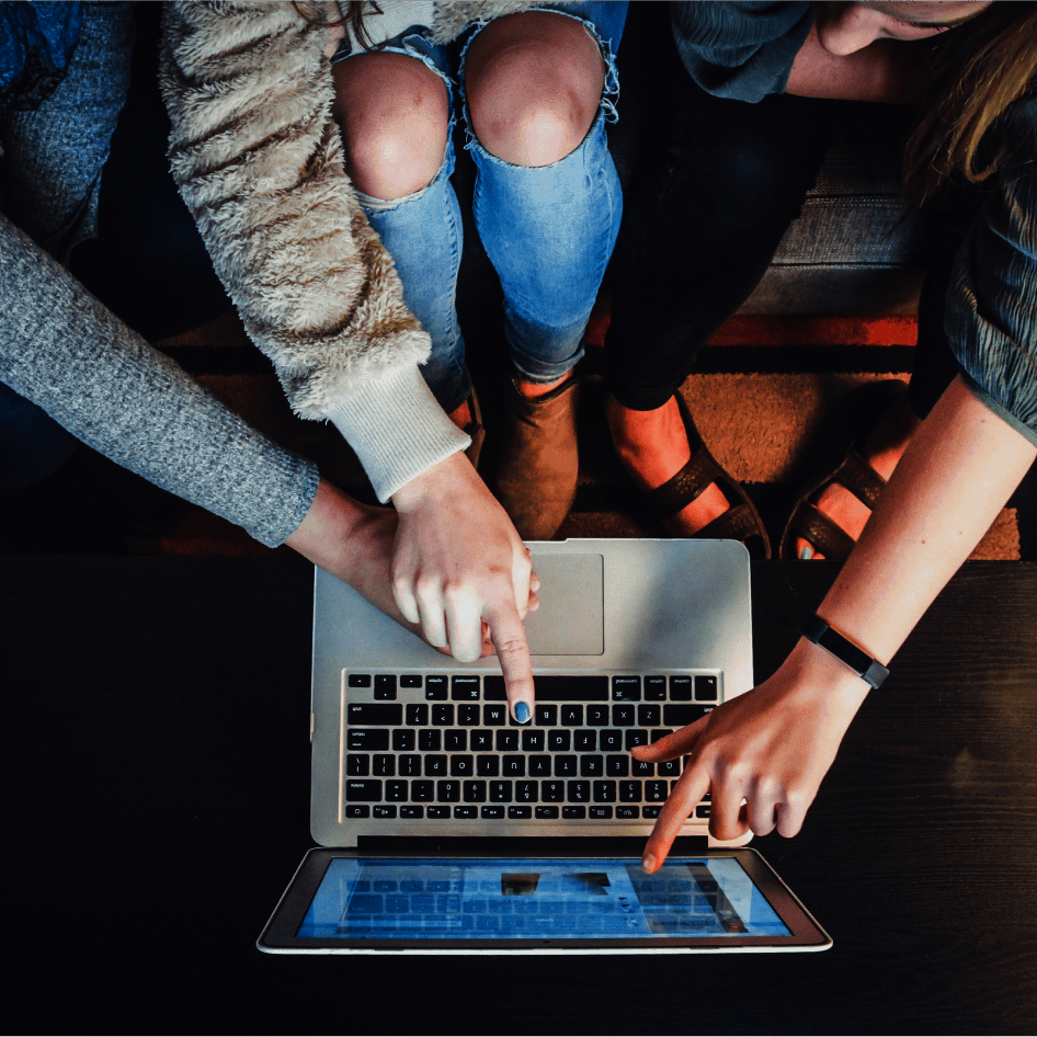 Finger zeigen auf Laptop Mehrere Finger zeigen auf die Inhalte eines geöffneten Laptops